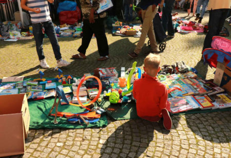 Junge sitzt vor seinen Flohmarktsachen | Muenchen mit Kind