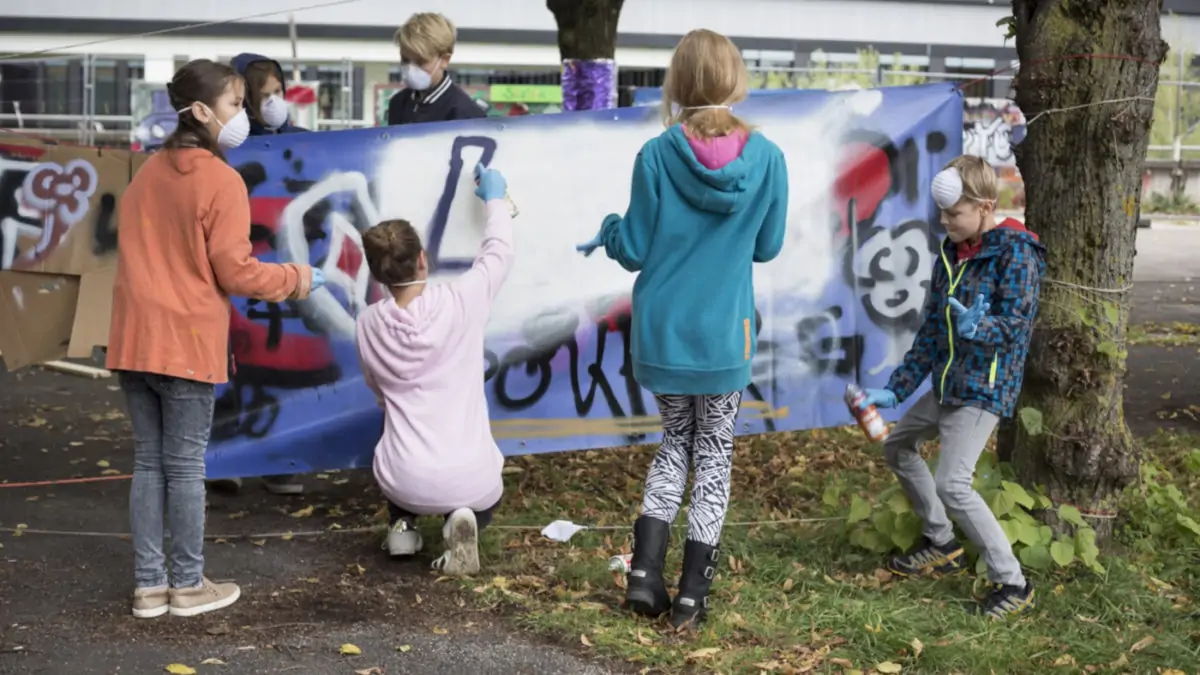 Kinder sprühen Graffiti beim kreativen Mitmachfestival