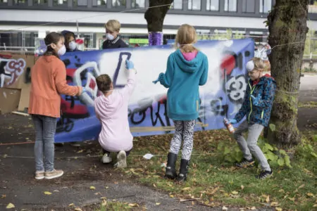 Kinder sprühen Graffiti beim kreativen Mitmachfestival
