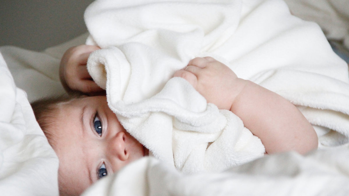Baby eingekuschelt im Bett | berlinmitkind.de