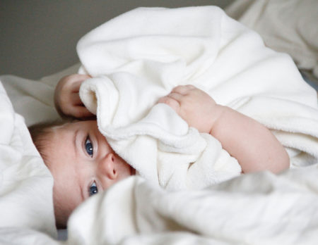 Baby eingekuschelt im Bett | berlinmitkind.de