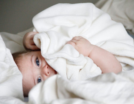 Baby eingekuschelt im Bett | berlinmitkind.de